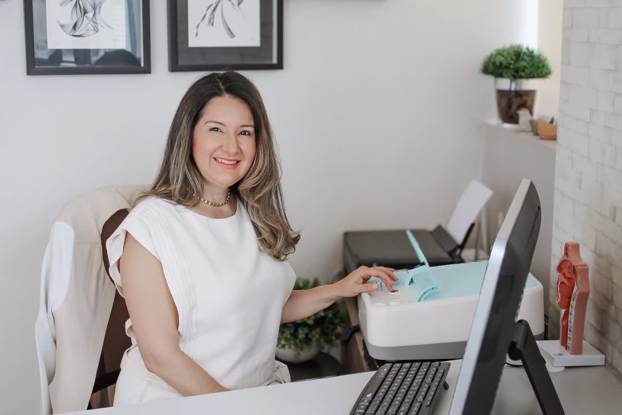Dra. Karyne junto a equipamento no consultório